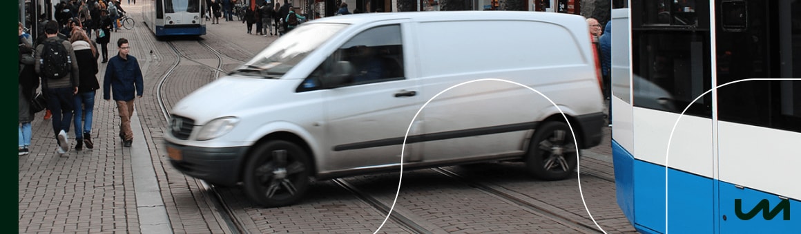 Een afbeelding van voertuigen die door een uitstootvrije zone in Amsterdam rijden.