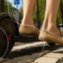 Een man rijdt op een goedgekeurde e-step door de straten van Amsterdam